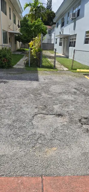 Raveled, potholed lot before the work