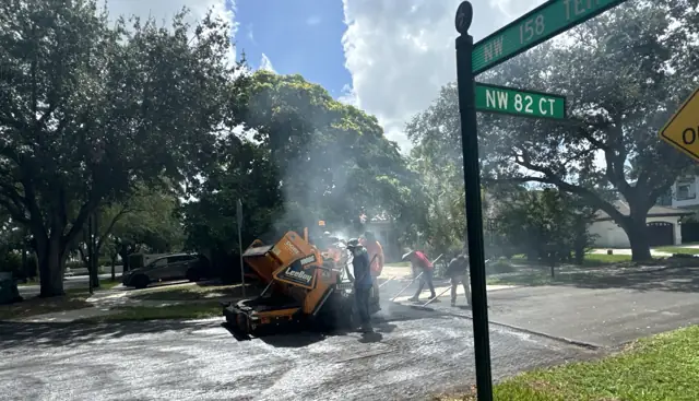 Residential Street Paving, Miami Lakes: Placing and raking hot-mix asphalt behind the paver