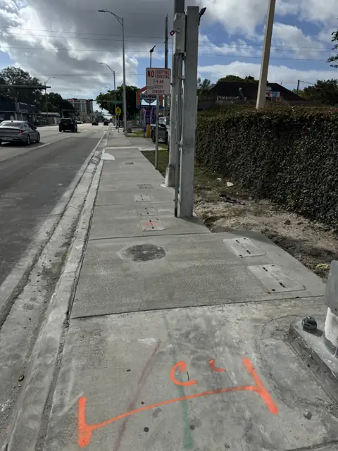 City of Miami Sidewalk Improvements: After: new walk flush with valve boxes and signal poles