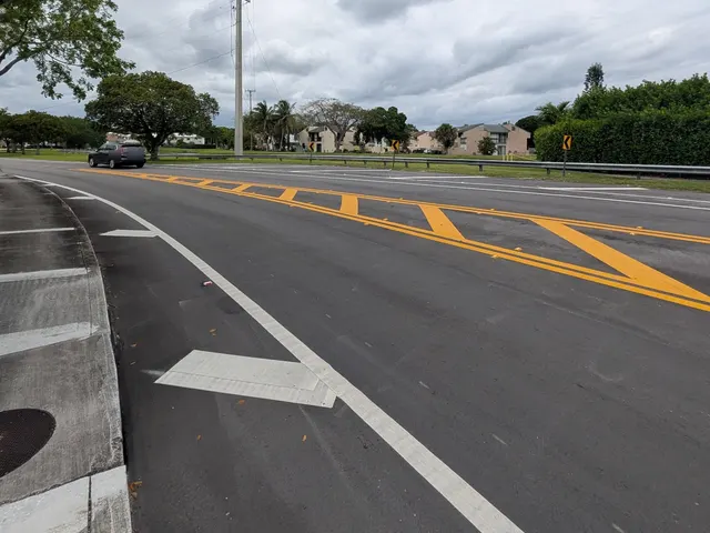 Palmetto Bay Median, Bike Lane & Striping Improvements: Crosshatched painted median and raised pavement markers through the curve