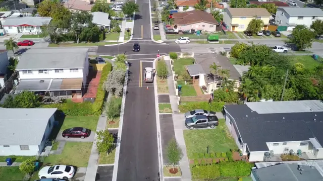 Sweetwater Neighborhood Roadway Improvements: Intersection approach with new asphalt, stop bar, double yellow centerline and ADA curb ramps