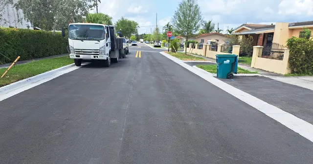 Sweetwater Neighborhood Roadway Improvements: New asphalt, curb and driveway aprons approaching the stop-controlled intersection