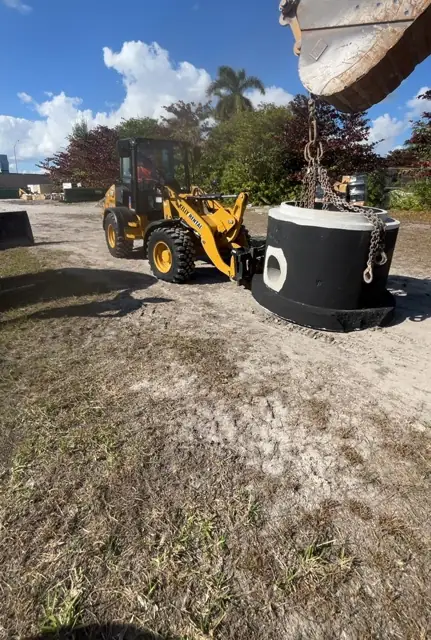 West Little River Sewer & Resurfacing: Loader delivering a precast manhole section