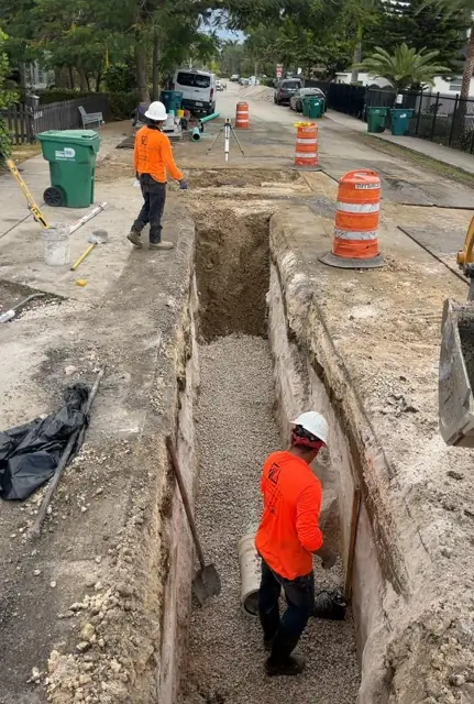 West Little River Sewer & Resurfacing: Shored trench with rock bedding, survey instrument set up